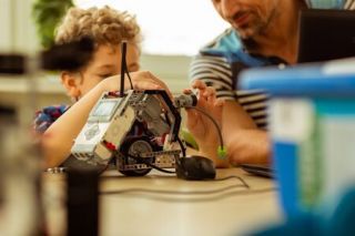 125876330 artificial intelligence selective focus of a small robot being constructed by a small cute child